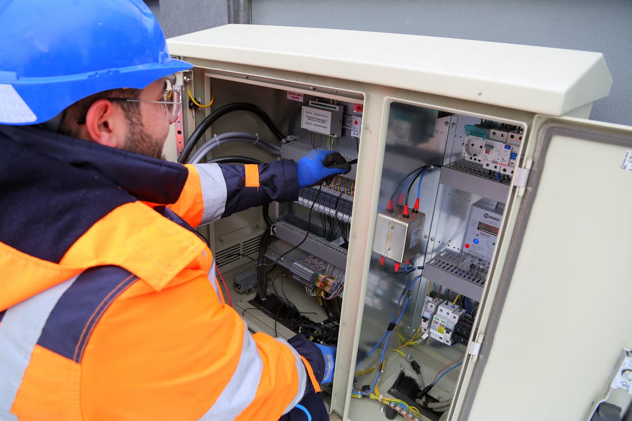 about-me-02 Engineer in safety gear working on an outdoor electrical panel, ensuring system functionality.