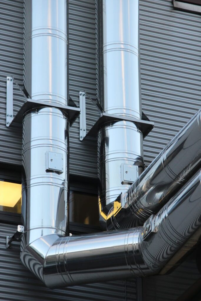The Entrepreneur’s Guide to Turning Ideas Into Profitable Close-up of shiny stainless steel pipes on an industrial building facade, showcasing modern technology.